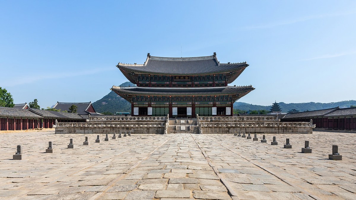 Geunjeongjeon, the throne hall of Gyeongbokgung Palace in Seoul, with Bugaksan mountain behind it on a clear day