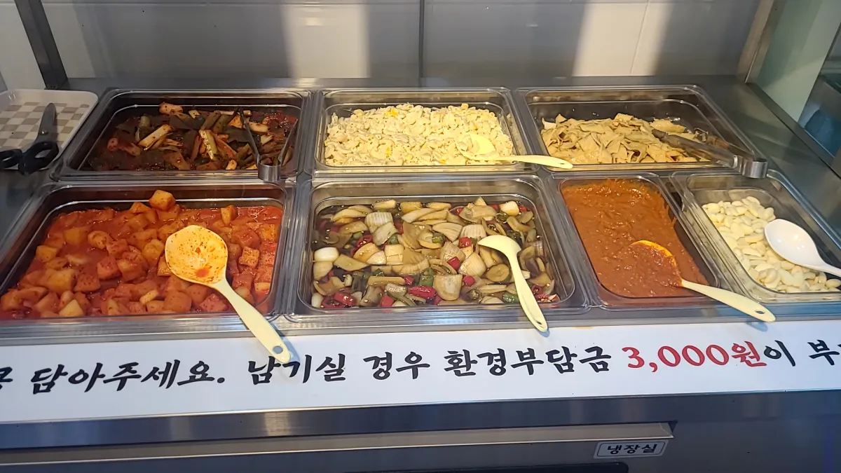 반찬리필-샐프선반에-양파짱아치-콘샐러드-어묵-깍두기-무말랭이-쌈장이-깔끔하여-놓여있다