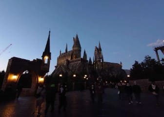 중세시대 궁전같은 외관의 건물에 노란색 조명이 비치는 사진