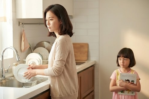 싱크대에서 설거지하는 엄마와 책을 들고 머뭇거리는 딸
