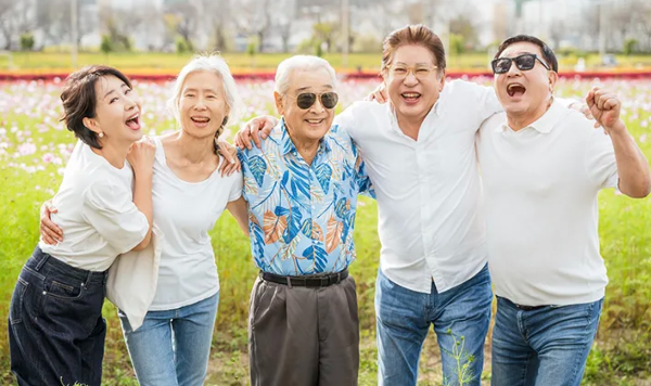 드라마 개소리의 시니어 배우들. 왼쪽부터 송옥숙, 예수정, 이순재, 김용건, 임채무. 꽃밭에서 서로 어깨동무를 하며 활짝 웃고 있다.