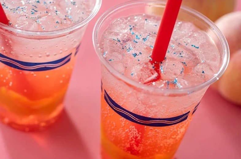 투명한 플라스틱 컵 안에 음료와 얼음 그리고 빨대가 들어가 있다.