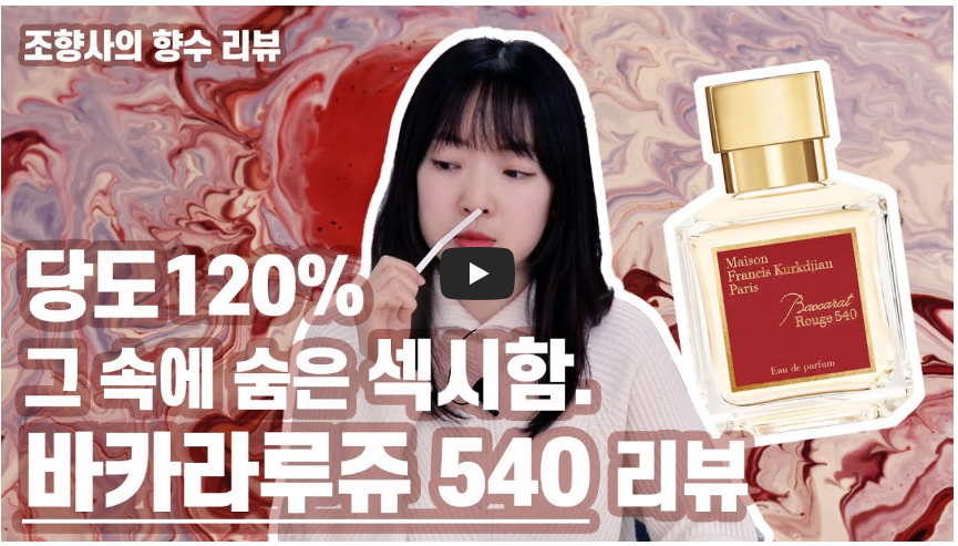 조향사의 향수 리뷰 영상 썸네일. 여성 리뷰어가 시향지로 향수를 맡고 있으며, 배경에는 마블 무늬와 Maison Francis Kurkdjian Baccarat Rouge 540 향수 병이 배치되어 있다. '당도 120% 그 속에 숨은 섹시함. 바카라루쥬 540 리뷰'라는 문구가 적혀 있다