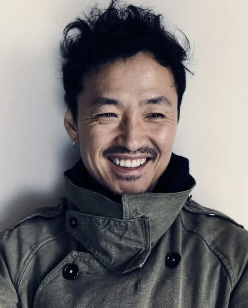 헝클어진-파마-머리를-한-강산에가-야상을-입고-활짝-웃고-있는-사진