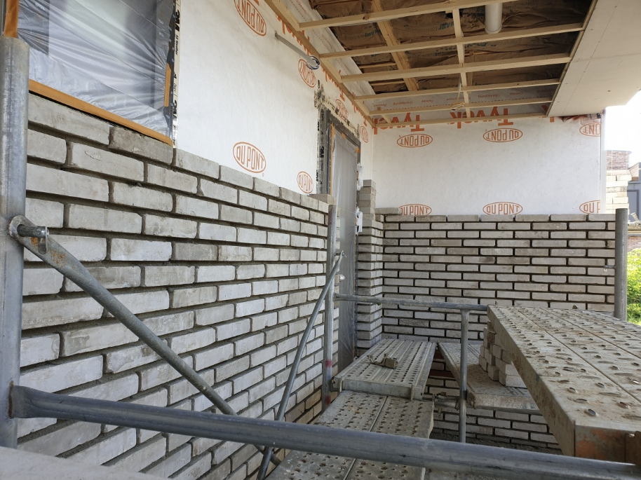 건물 외부를 벽돌로 조적하고 있는 모습이 담긴 사진