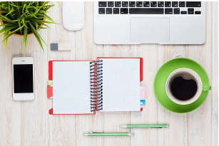 자격증 공부를 위한 노트와 노트북, 핸드폰과 커피한잔이 책상에 준비되어 있는 사진