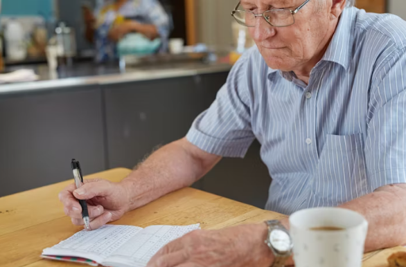 가계부를 기록하며 고민하는 노년 남성의 모습