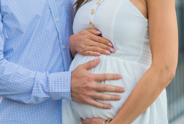 임산부와 그 배를 만지고 있는 남편의 모습.