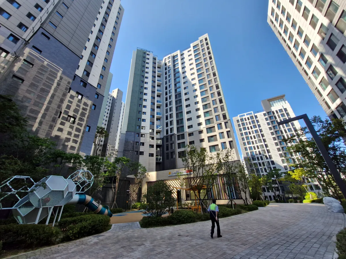 앞에-전부-아파트로-둘러쌓여-있고-그-사이-경비원-아저씨가-걸어가고-있는-모습