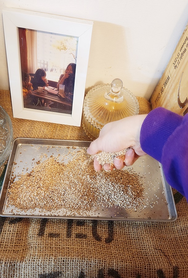 원두 포대 위에 작은 쟁반을 두고 모래를 덮어주느모습