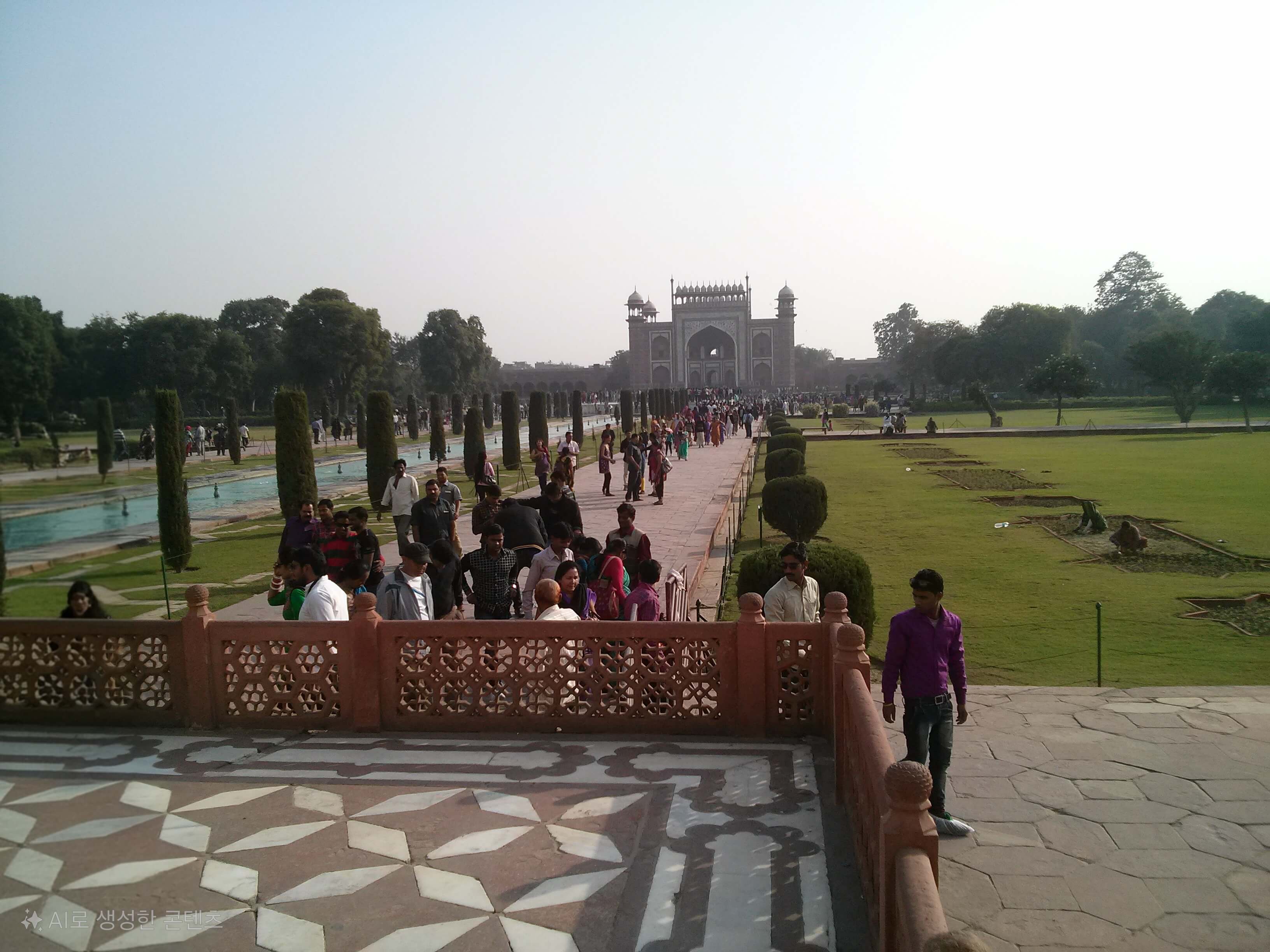 "타지마할 정원의 넓은 잔디밭에서 뙤약볕을 견디며 수작업으로 잔디를 고르고 보수하는 인도 현지 일꾼들의 모습"