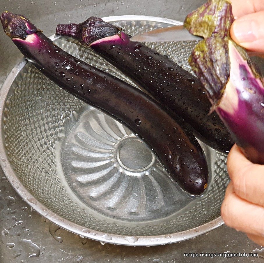 가지 무침을 하기위해 가지의 꼭지 부분을 칼로 제거하는 사진