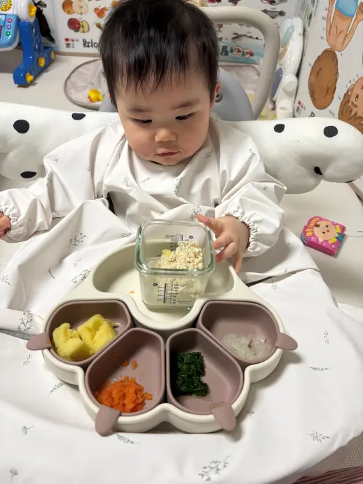 이유식을 호기심가득한 표정으로 바라보는 아이