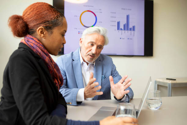 회의실에서 중소기업 경영자에게 자료를 설명하는 중소기업진단사의 모습