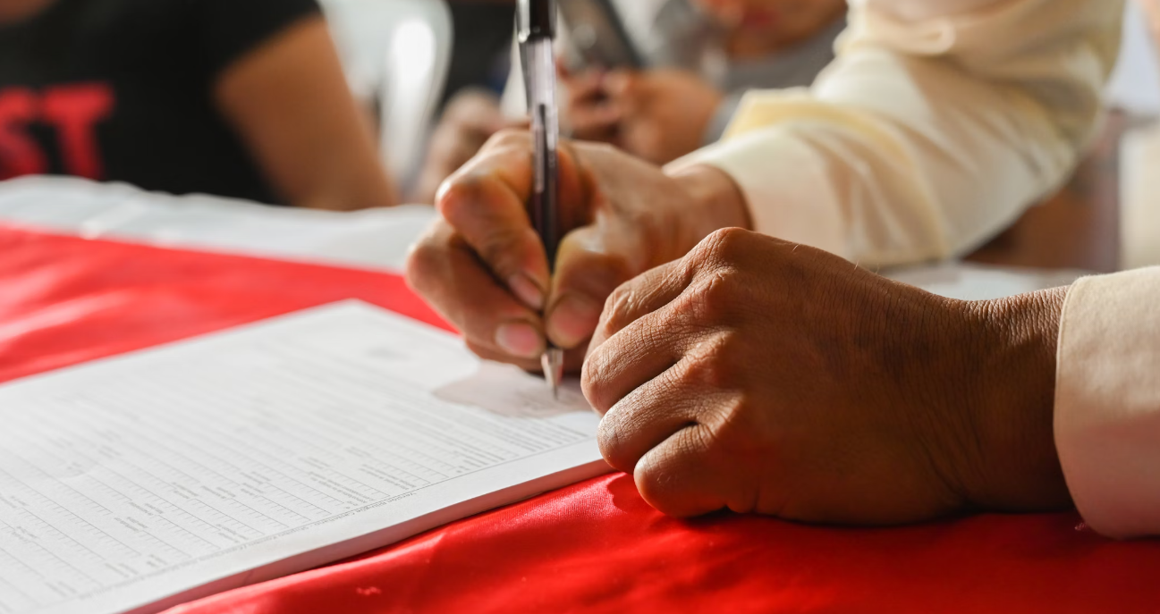 청년이 계약서에 싸인하는 모습