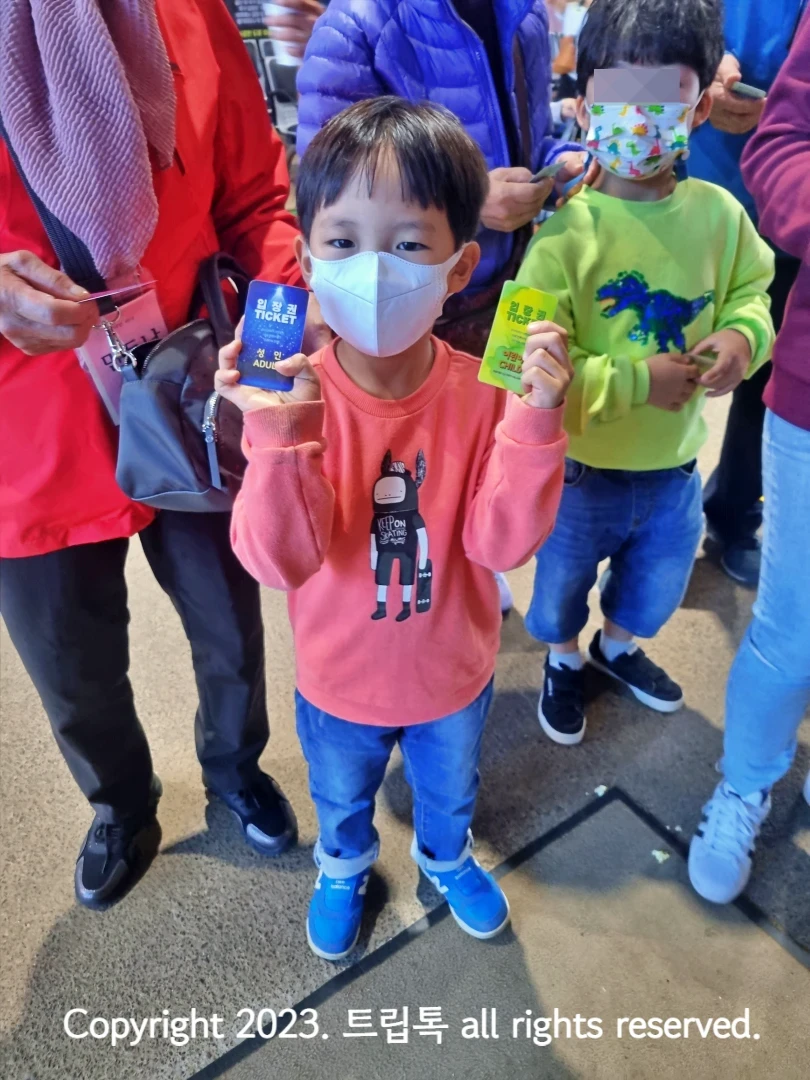 양손에 티켓을 들고 있는 아이