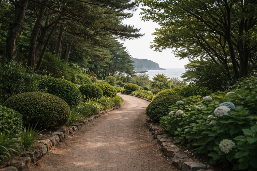 천리포수목원의 바다 가까운 정원길과 나무, 차분한 초록 풍경이 함께 보이는 모습