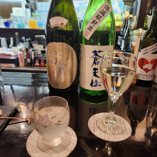 테이블 위에 사케병 2개와 사케를 따라놓은 잔 2개가 올려져 있다.