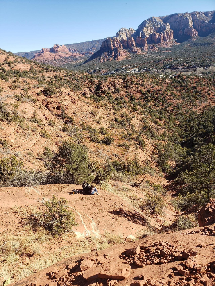 세도나 에어포트 루프 트레일에서 붉은 바위 위에 앉아 풍경을 감상하는 젊은이들