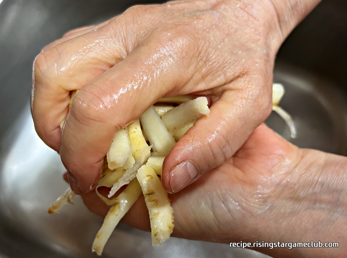 쓴 맛을 제거한 도라지를 꺼내 물기를 짜는 사진