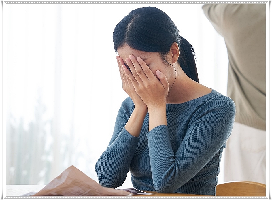 두 손을 얼굴을 감싸 쥔 여성의 모습