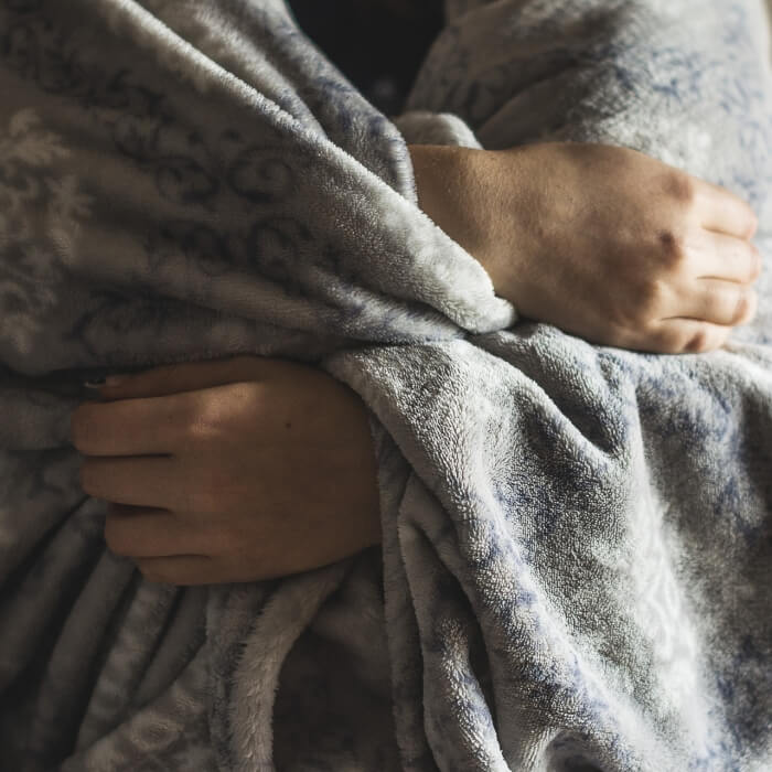 사람이-추워서-담요-덮고-있는-사진