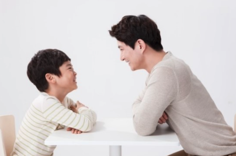 부모의 양육태도가 아이의 학습동기를 바꾼다._아동과 아빠가 마주보면서 웃고 있다.