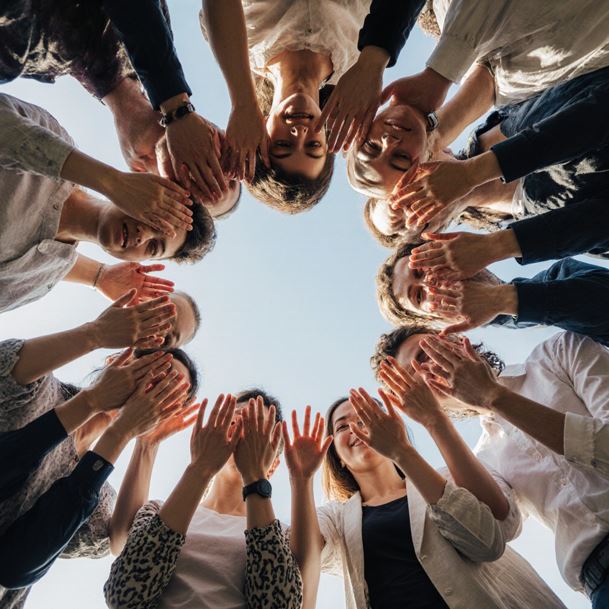 다양한 사람들이 원형으로 서서 손은 맞대고 서로를 지지하는 모습