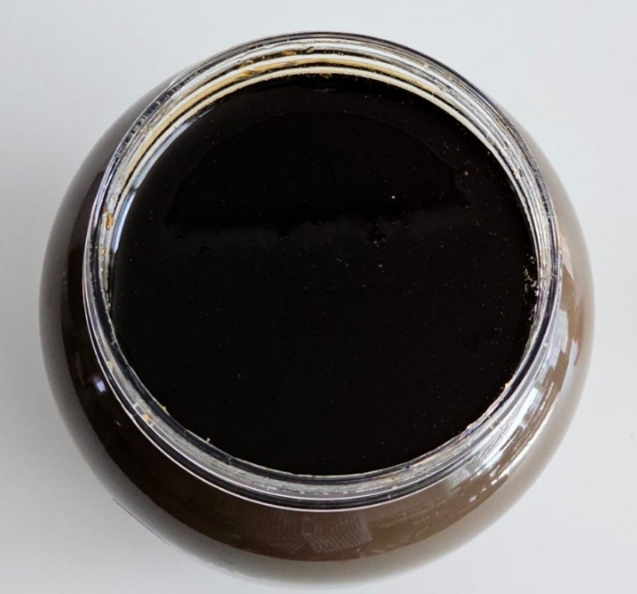 야생에서 채취를 한 매실을 고아서 만든 매실조청을 하얀 바닥 위에 투명한 유리병에 가득 담아 놓은 것을 두고 찍은 사진