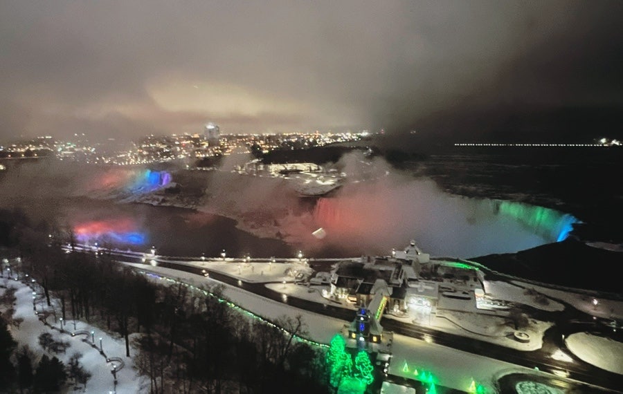 Nighttime Niagara Falls illuminated with colorful lights seen from Embassy Suites Niagara Falls