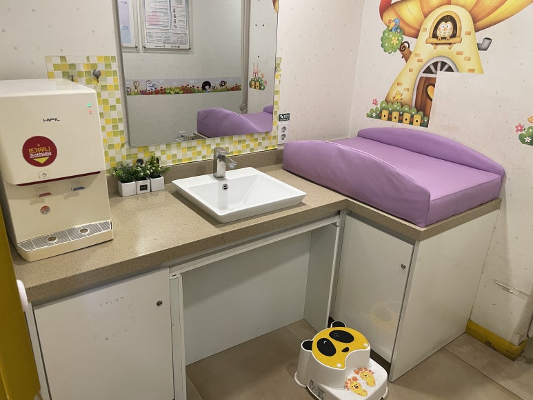 수유실 내부 기저귀갈이대와 세면대 정수기 이미지