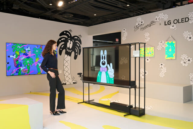 LG전자가 세계적인 아트페어 '프리즈 뉴욕'에 참가해 2025년형 LG 올레드 에보(evo) 등 TV 신제품의 압도적 화질로 표현한 팝아트를 선보인다. 모델이 LG 시그니처 올레드 T의 투명한 화면을 통해 재생되는 팝아트를 감상하고 있다.