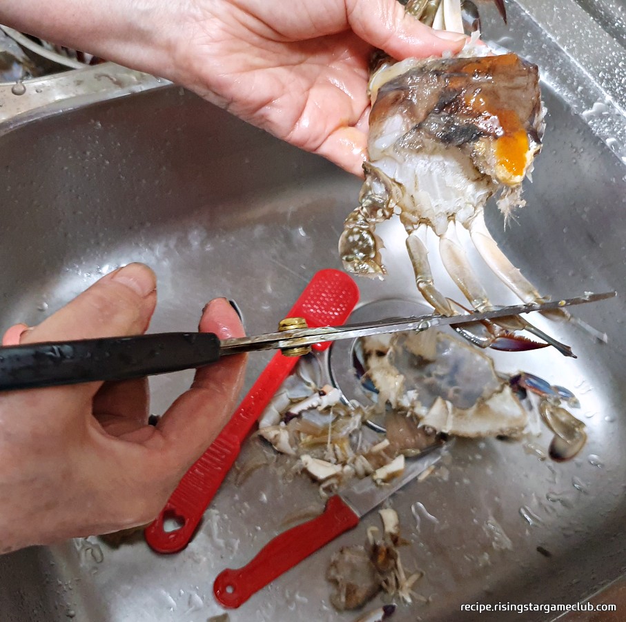 맛있는 양념게장에 들어갈 꽃게의 다리 끝에 뾰족한 부분을 가위로 잘라 다듬는 사진