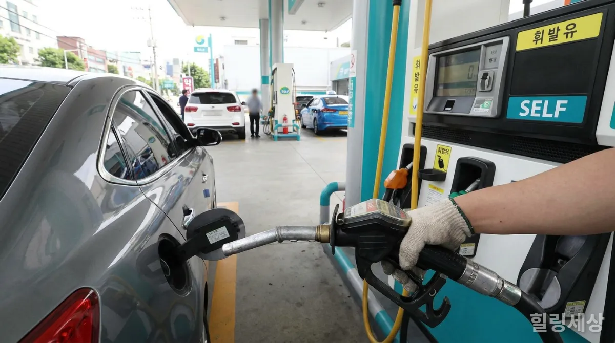 한국 셀프 주유소에서 주유기 손잡이를 잡고 천천히 주유하는 모습