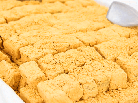 네모난 인절미가 가득 들어있는 떡판이다. 황색 콩고물이 가득 묻은 인절미다.