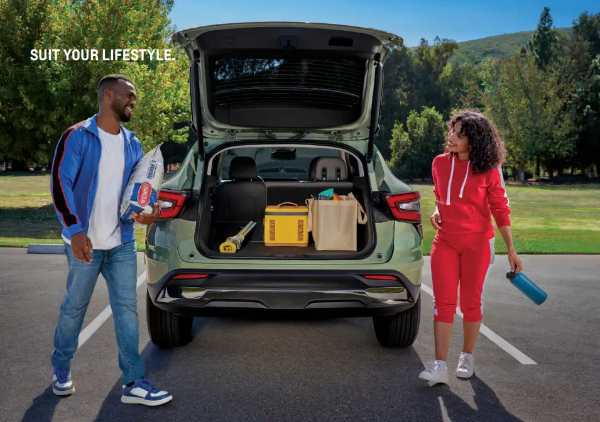 쉐보레 트렁크에 짐을 싣고 남녀가 마주보며 웃고 있는 모습