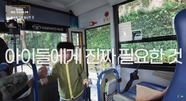 아이들에게 진짜 필요한 것이라는 자막과 함께 버스에 탑승한 어린이가 어른과 손을 맞잡는 부모교육 방송 장면
