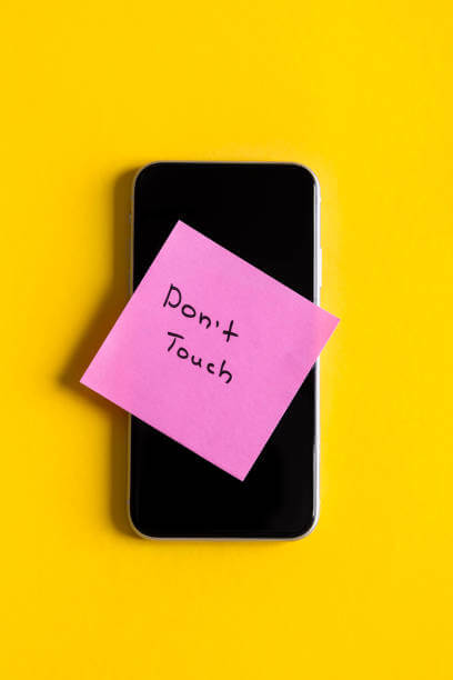 디지털 디톡스 실천을 위해 휴대전화에 DON't TOUCH라고 써서 붙여 놓은 사진