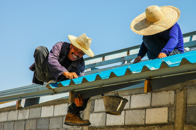 슬레이트 지붕을 철거하고 새 지붕을 설치하는 작업자들의 모습