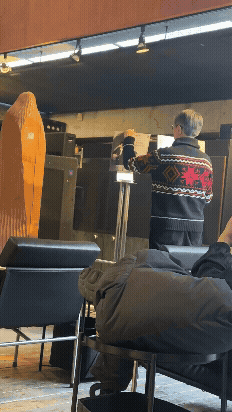 파주 헤이리 카메라타 내부에서 음악이 바뀔 때 곡 설명 안내판을 조용히 교체하는 모습, 클래식 감상 공간의 차분한 분위기