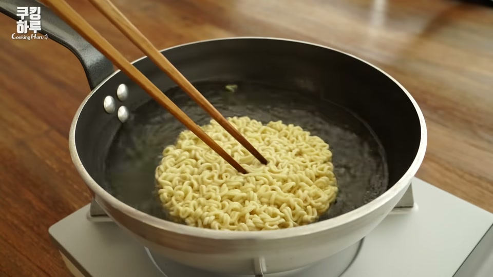 끓는 물에 라면 사리를 넣는 장면