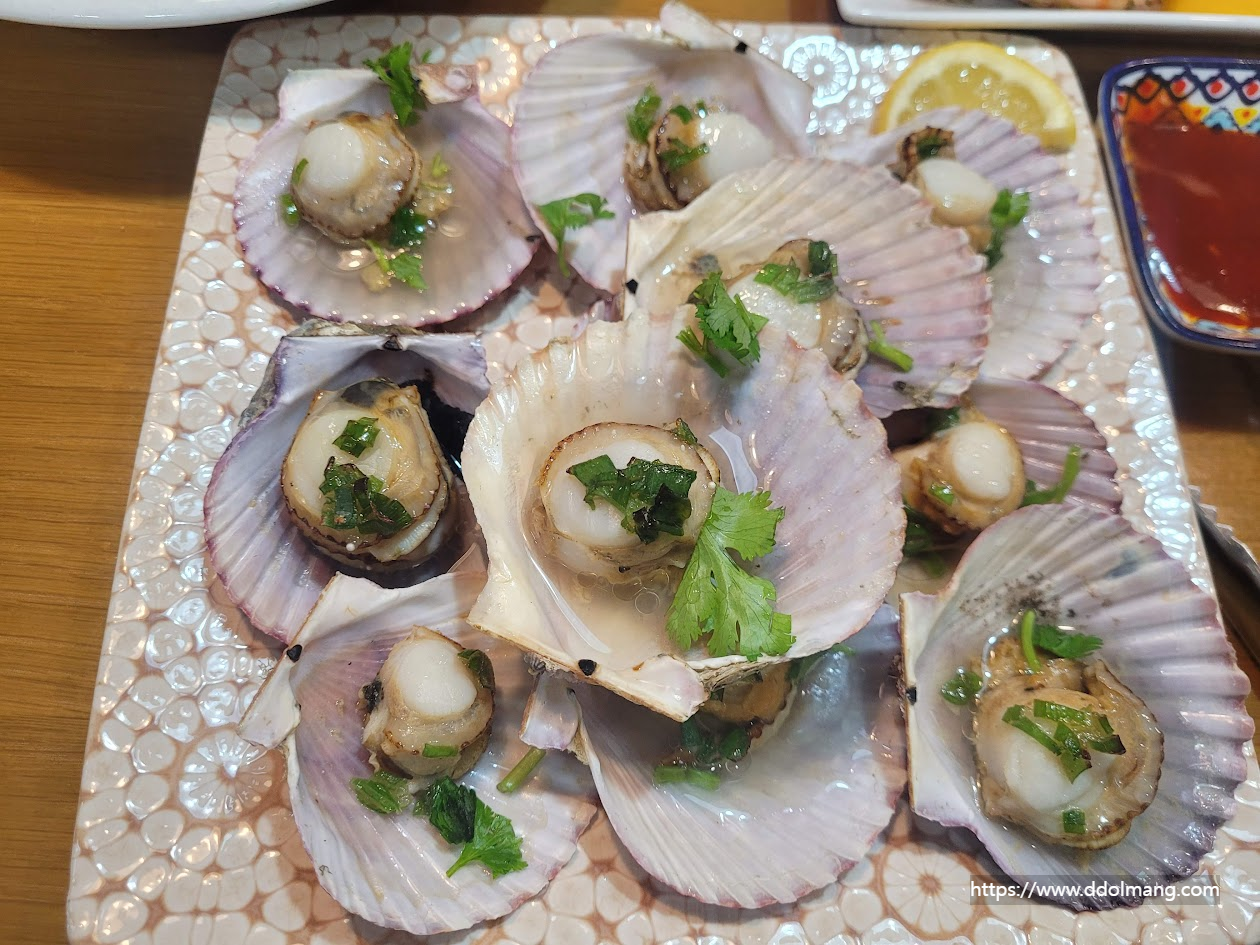 고수 레몬즙 파기름 등 양념을 올린 가리비