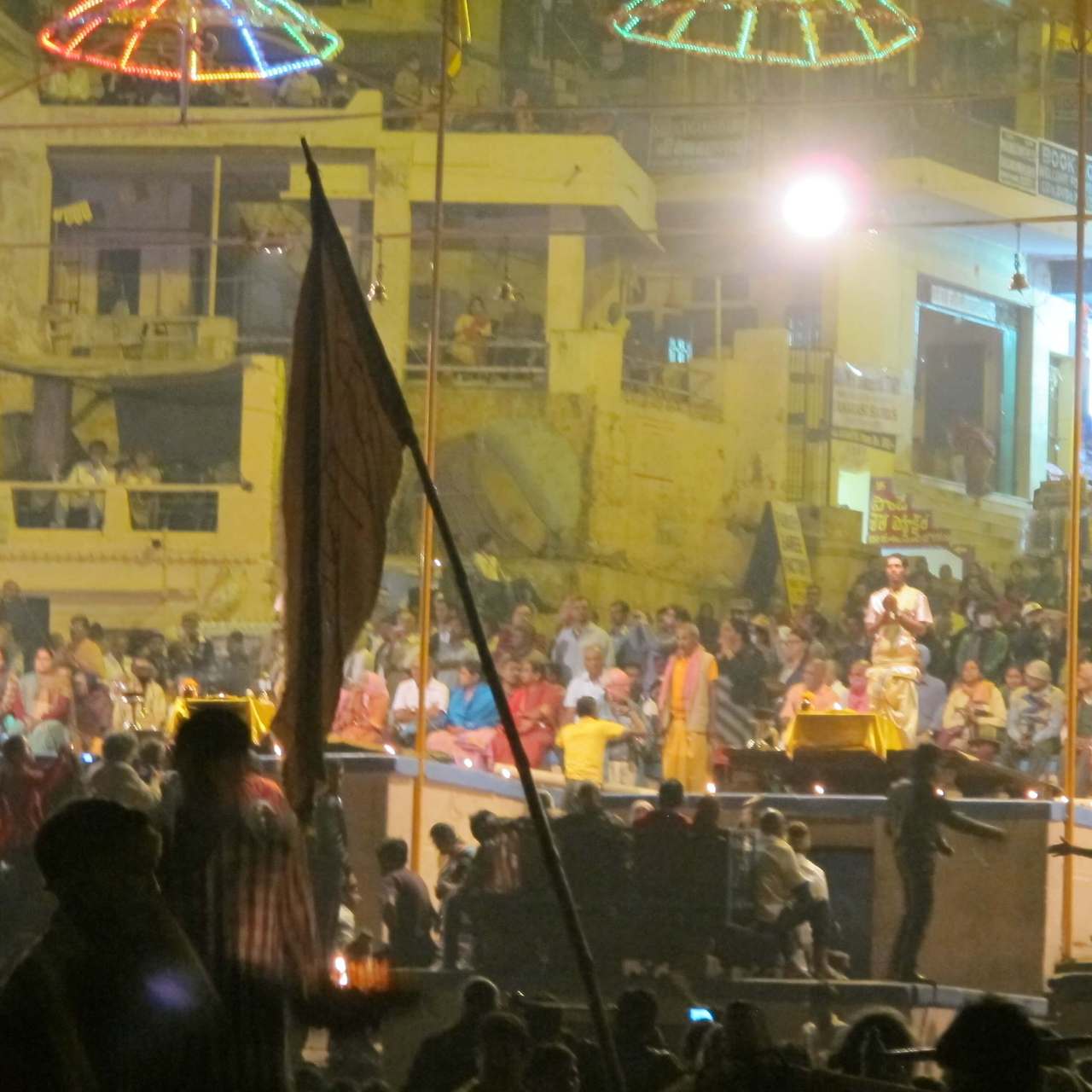 아르띠 뿌자 의식 중 사제들이 불을 들고 의식을 행하는 모습과 그 뒤로 모여든 수많은 관중