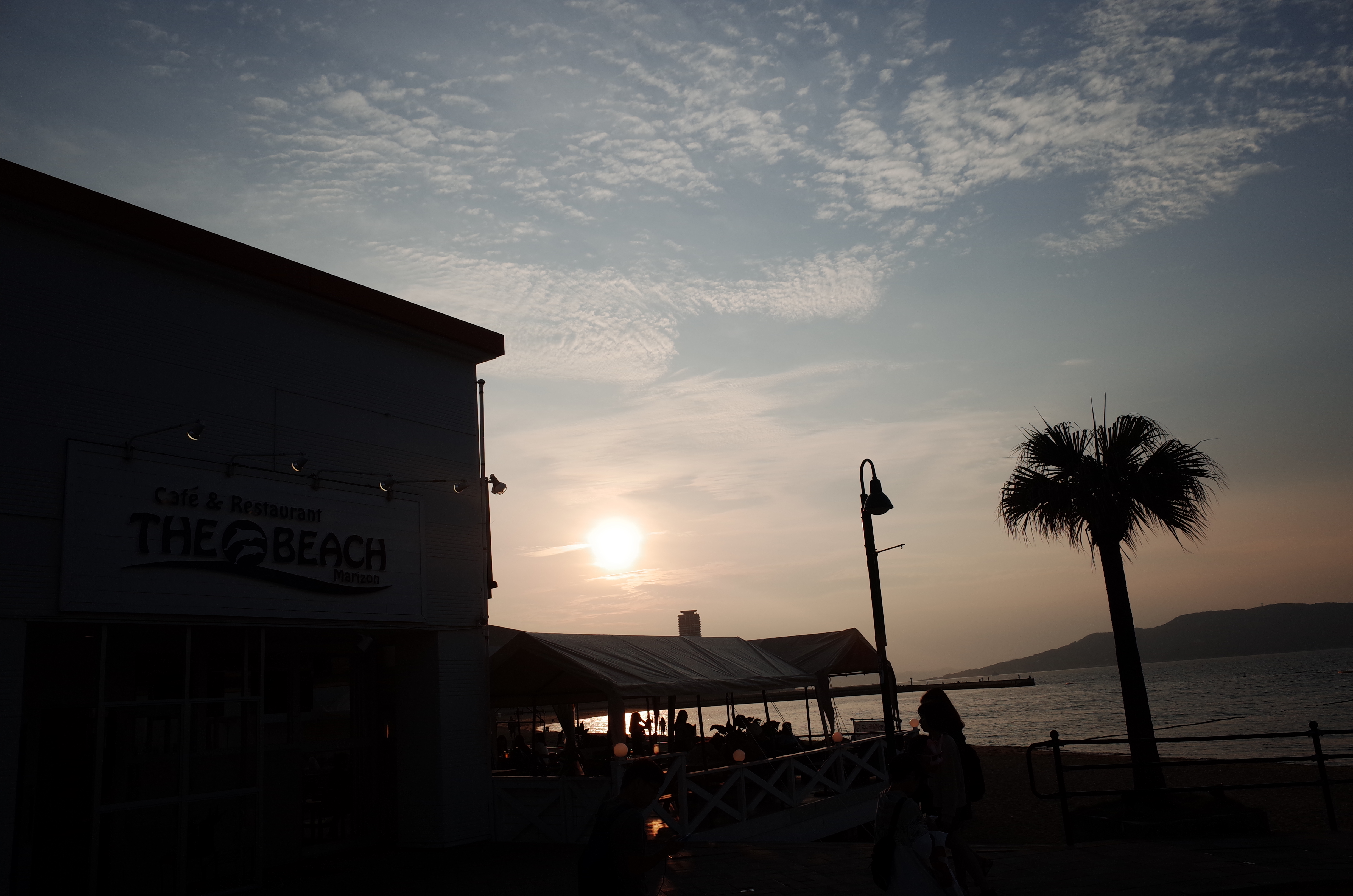 '맘마미아' 카페 건너편으로 보이는 모모치 해변의 붉은 노을과 야자수 실루엣.