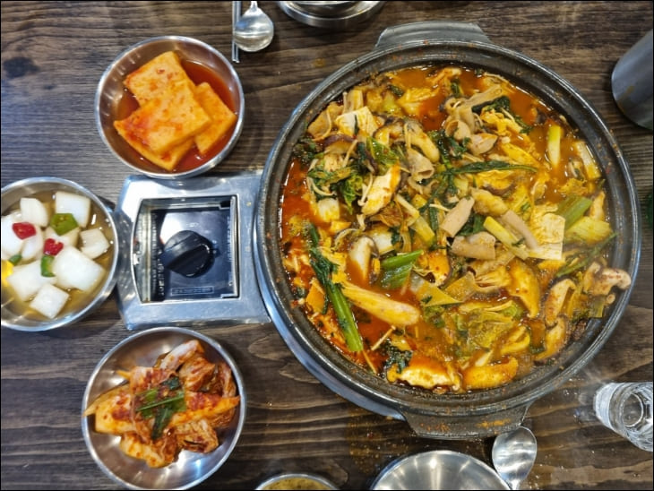 푸짐한-곱창전골과-김치-반찬-등이-상에-놓여있다.