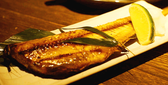 네모난 하얀 접시에 잘 구워진 고등어구이 한 마리가 놓여있고 라임 한 조각도 곁들여졌다.