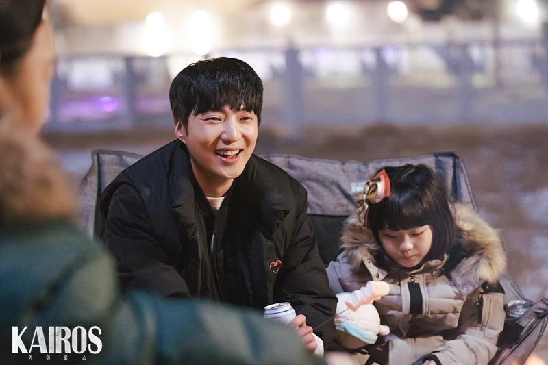 야외 의자에 앉아 캔을 든 채 아역 배우 옆에서 웃는 강승윤