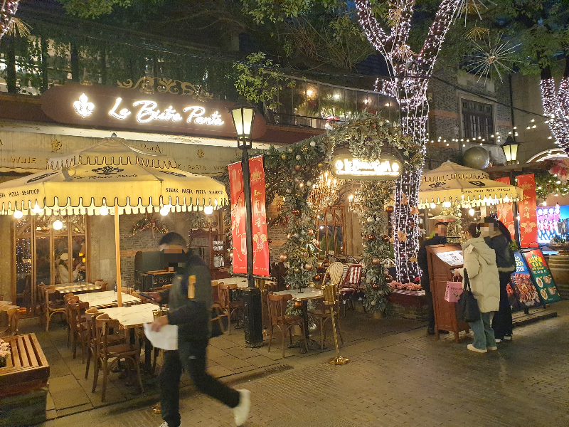 어둑해진 저녁 조명이 들어온 Le Bistro Panta. 밖에 있는 메뉴판을 보고 있는 손님들