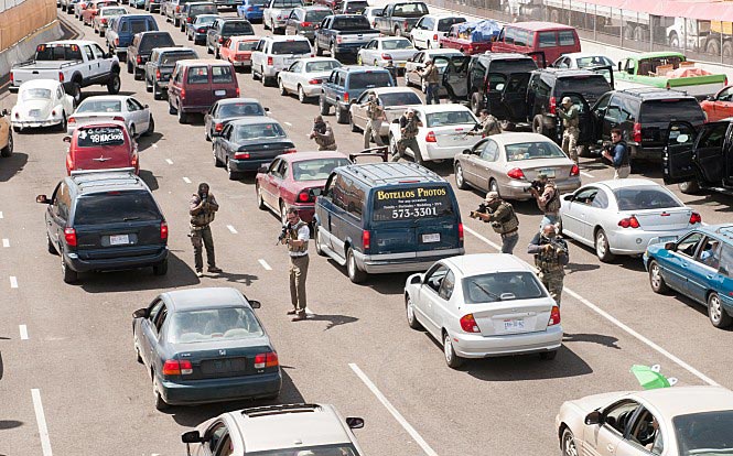 도로에서 사람들이 총을 들고 서있다.