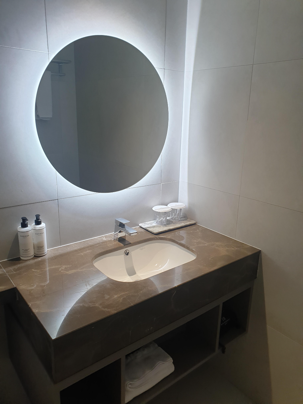 은은한 간접 조명이 있는 거울이 달린 세면대